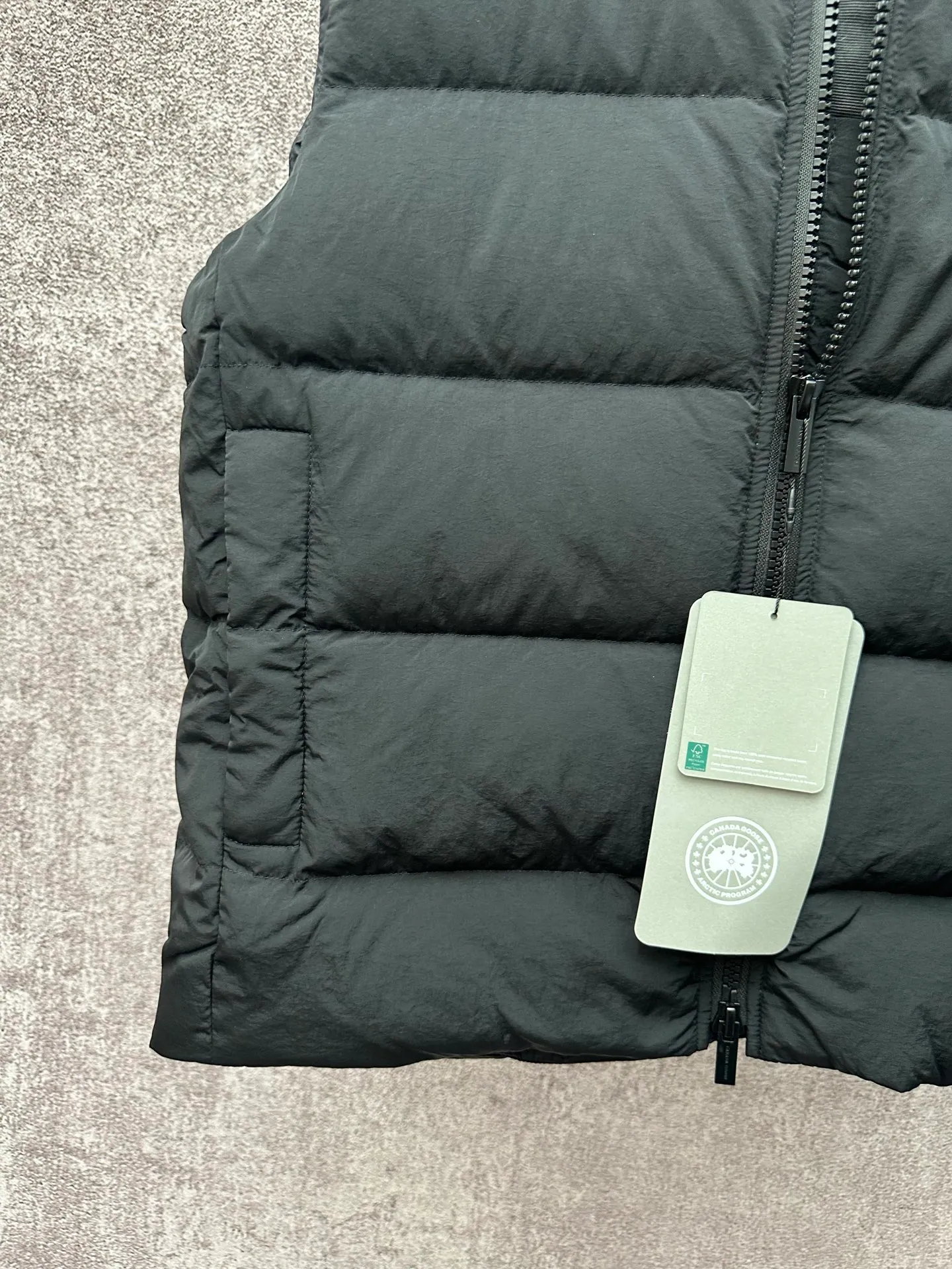 P720 Canada Goose Badge Down Vest Fabric selection: The use of high-quality protective nylon fabric not only enhances the wear resistance of the surface, but also takes into account wind resistance, ensuring excellent performance in various harsh weather conditions.  90 national standard high-quality white duck down: selected high-loft down, weighing 160g, light and warm, with excellent temperature locking performance and good resilience.  Three-dimensional quilting process: Precision thread reinforcement to prevent velvet drilling and ensure that the fluffy and resilient elasticity lasts as new.  Details: The ribbon is woven with polyester as the base, and the brand letters are decorated on the ribbon through high-precision computer embroidery. The edges of the pattern are clear, the stitches are fine and even, and multiple layers of embroidery thread are stacked to enhance the three-dimensional effect. Accessories: One-to-one customized logo, one-to-one customized zipper puller, one-to-one customized three-label SIZE: S M L XL